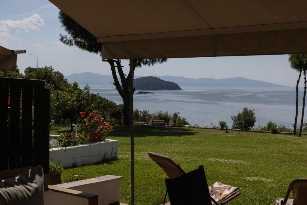 a view of the ocean from a lawn with an umbrella at Iraklitsa View in Iraklitsa
