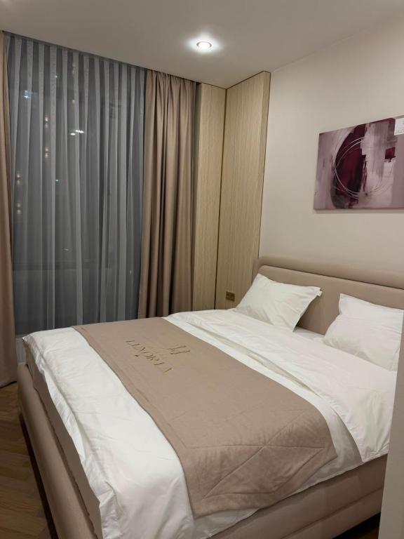 a bedroom with a large white bed with a window at Luxoria hotel in Astana