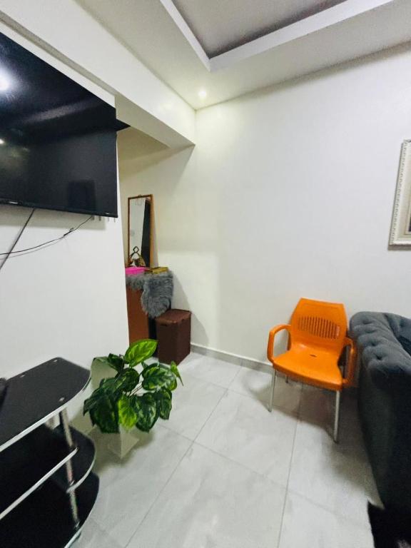 a living room with an orange chair and a couch at Mombasa 1 Bedroom Apartment in Mombasa