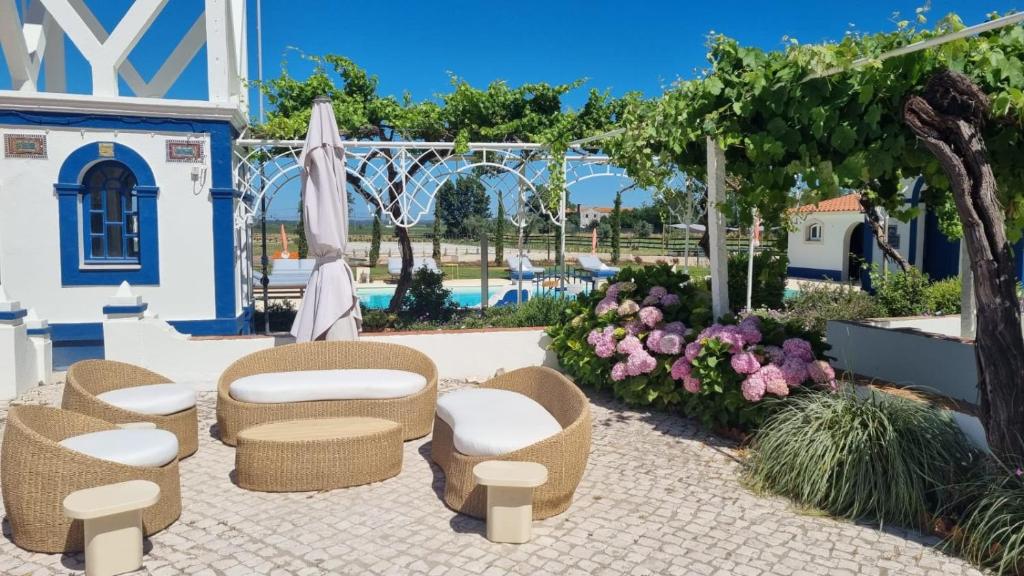 eine Terrasse mit Stühlen und Sonnenschirmen sowie ein Pool in der Unterkunft Marchanta Riverside Hotel in Santarém