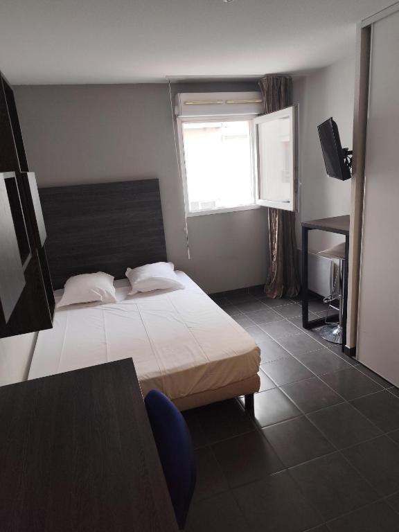 a hotel room with a bed and a window at City Résidence Nice in Nice