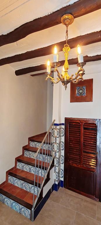a staircase with a chandelier in a house at Casa la Solana 1915 in Lucena del Cid