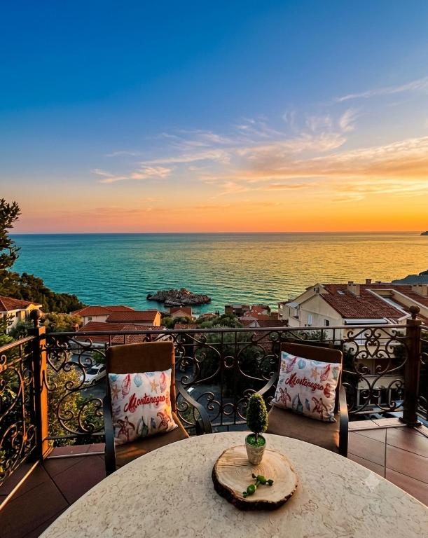a view of the ocean from a balcony with a table and chairs at Turkuaz Boutique Hotel in Sveti Stefan