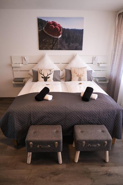 a bedroom with a large bed with two ottomans at Albview-Apartment1 -zentral-Nähe Klinik-Therme-Agilent in Waldbronn
