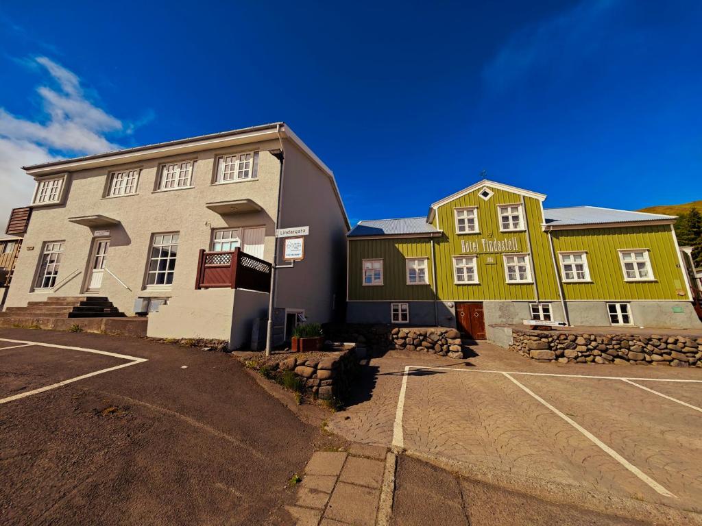 two buildings in a parking lot next to a street at Hótel Tindastóll in Sauðárkrókur
