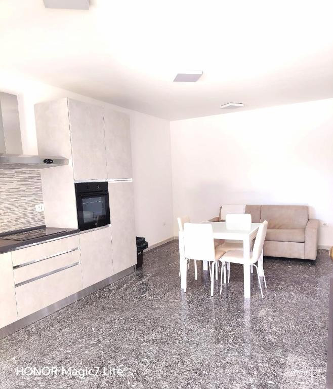 a kitchen with a table and chairs and a couch at Brezza Marina in Tortoreto Lido