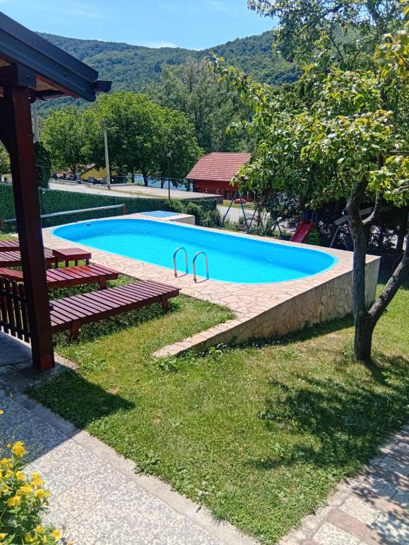 a swimming pool with two benches and a picnic table at Vikendica Andrija Drina in Gvozdačko Polje