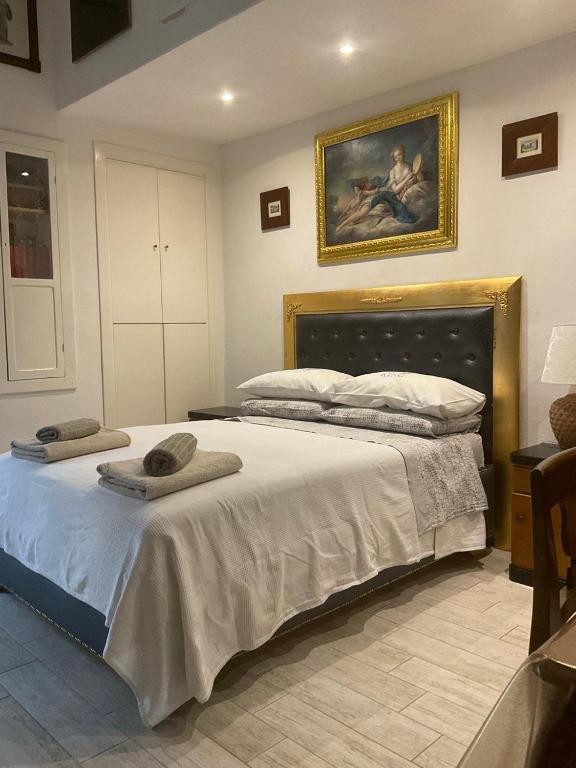 a bedroom with a large bed with a painting on the wall at ADRIANA in Pisticci