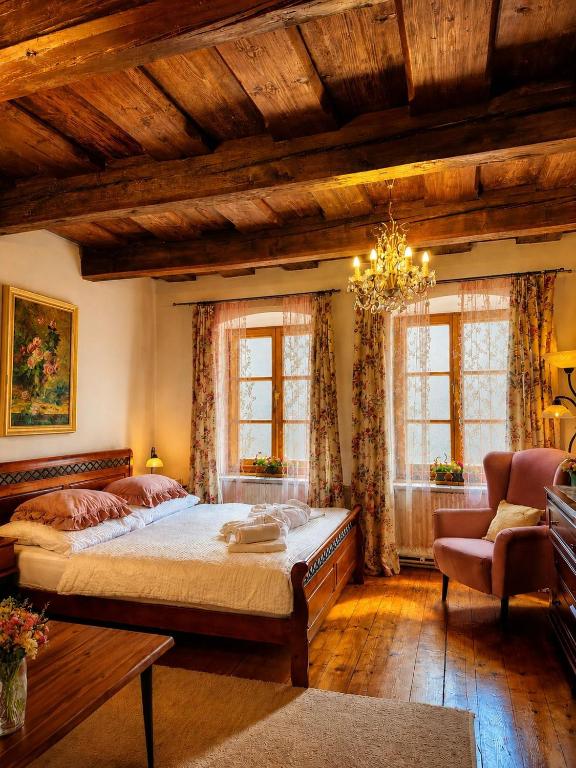 a bedroom with a large bed and a chandelier at Pension Nina in Český Krumlov