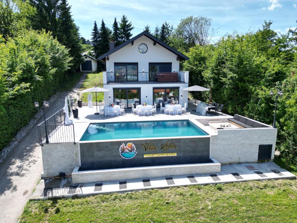 a house with a swimming pool in front of a house at Vila Ajlin Luxury Oasis Heaven in Sarajevo