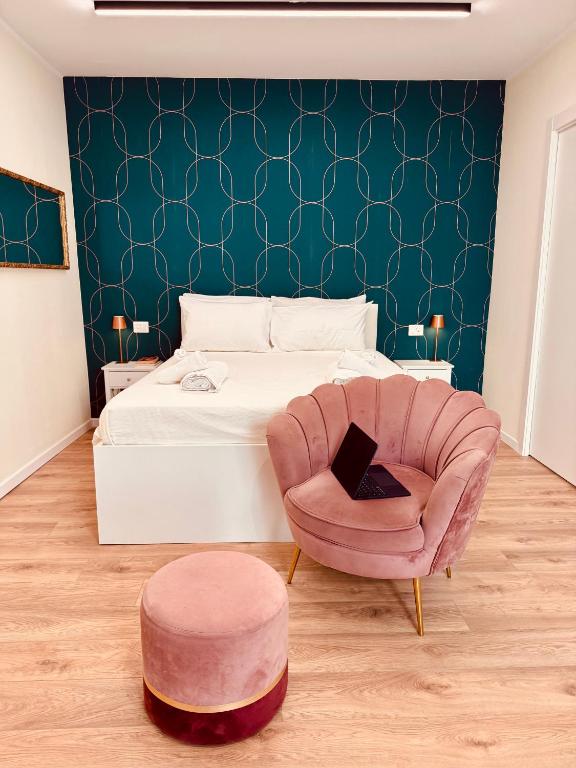 a bedroom with a bed and a chair with a laptop at Suite in Centro in Vasto