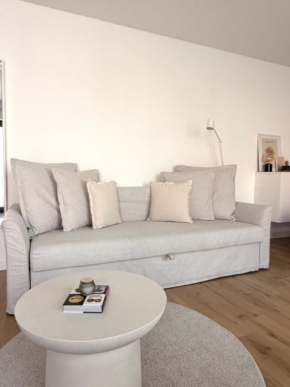 a white living room with a white couch and a table at Luxury Apartment Vorstetten Modern Zentral in Vörstetten