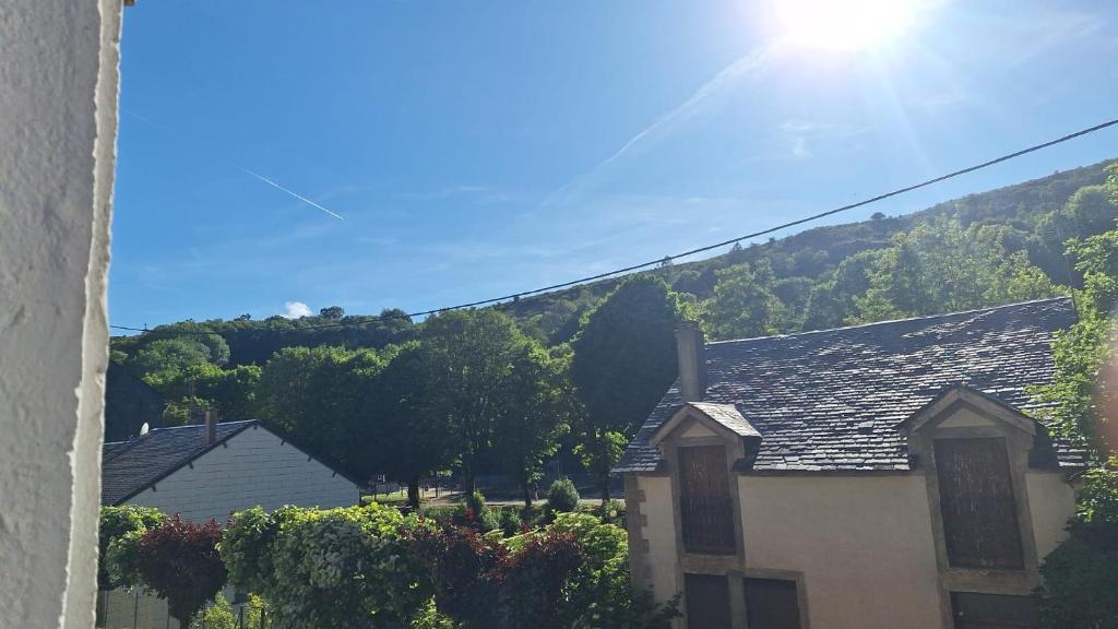 a house with a mountain in the background at La maison COP&CO in Murat-sur-Vèbre