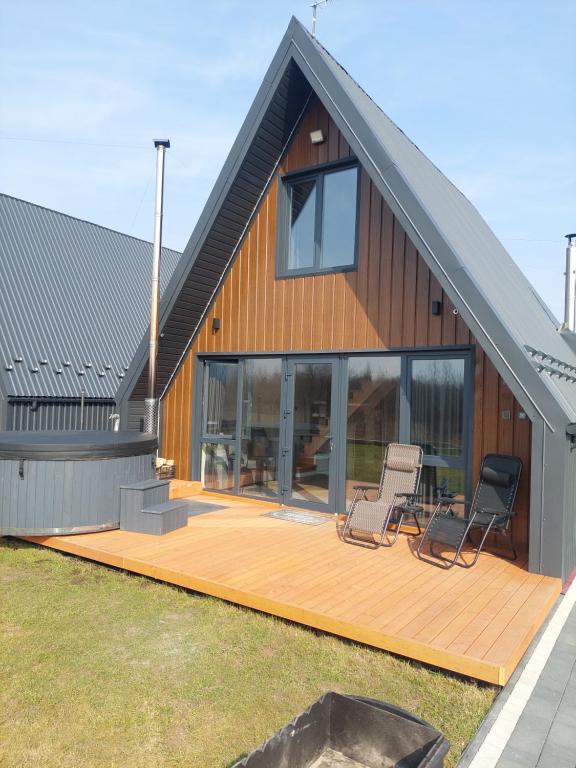 a house with two chairs on a wooden deck at zatyshnyy dvoryk Затишний Дворик in Kolomiya