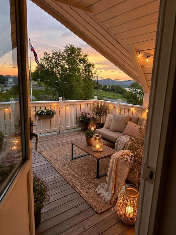 a patio with a couch and a table on a deck at Willes Wellness Paradise in Herjenes