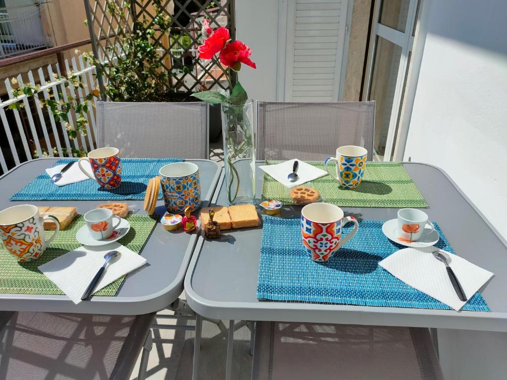 a table with cups and plates of food on it at La Casa dello Zio Pollo in Dogliani
