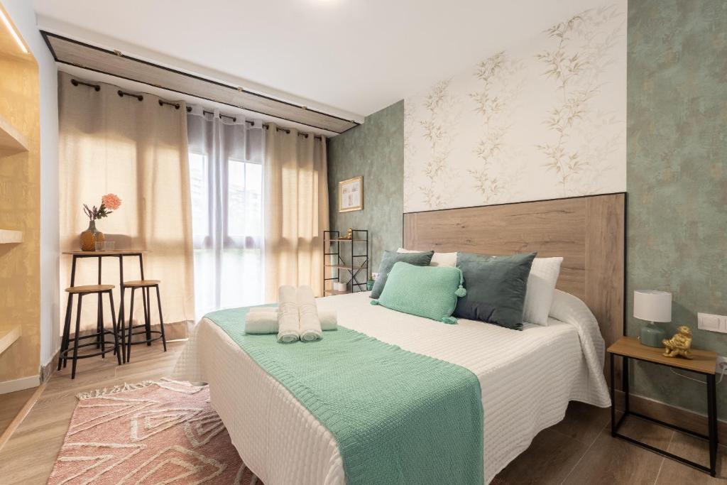a bedroom with a large bed with blue pillows at Emarooms Boutique Laredo in Laredo