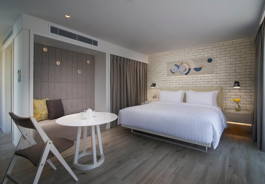 A bedroom combining a large bed with a small dining or work table and folding chairs.