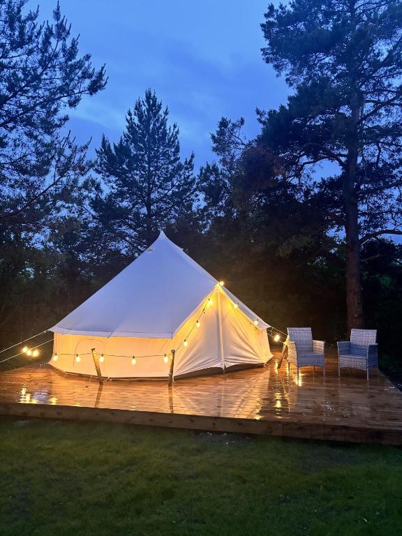 a white tent with lights on a deck at night at Anniksson Glamping Telk- Loodustelk in Virtsu