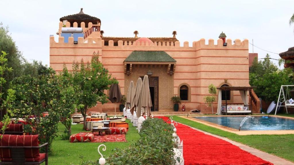 a building with a red carpet next to a swimming pool at Riad Marjana in Marrakesh