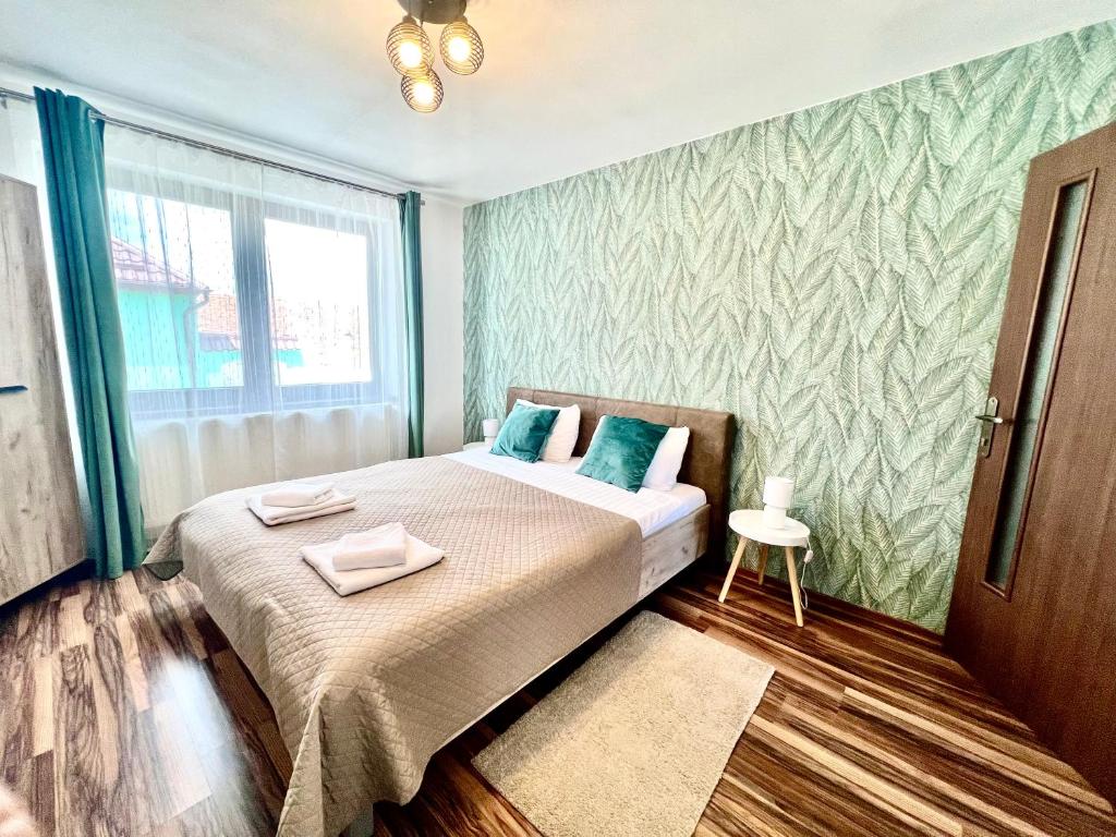 a bedroom with a bed with two towels on it at S-HOUSE Avrig , Apartament cu Aer Condiționat, 2 Dormitoare, Bucatarie, Terasa , Curte Privată Parcare Gratuită in Avrig