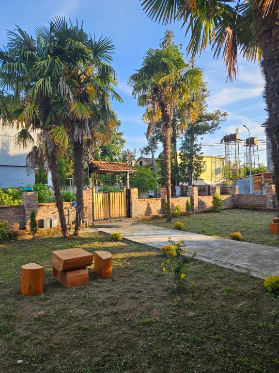 a park with a bench and palm trees and a gate at Guesthouse Las Palmas in Ureki