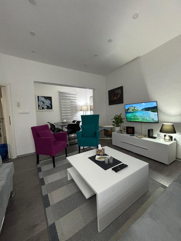 a living room with a couch and chairs and a tv at Apartman DIN in Travnik