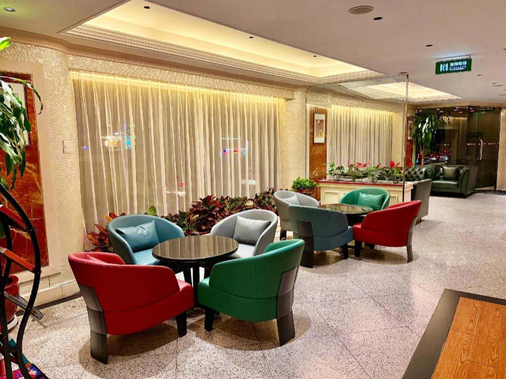 a lobby with colorful chairs and tables in a building at Macau Masters Hotel in Macau