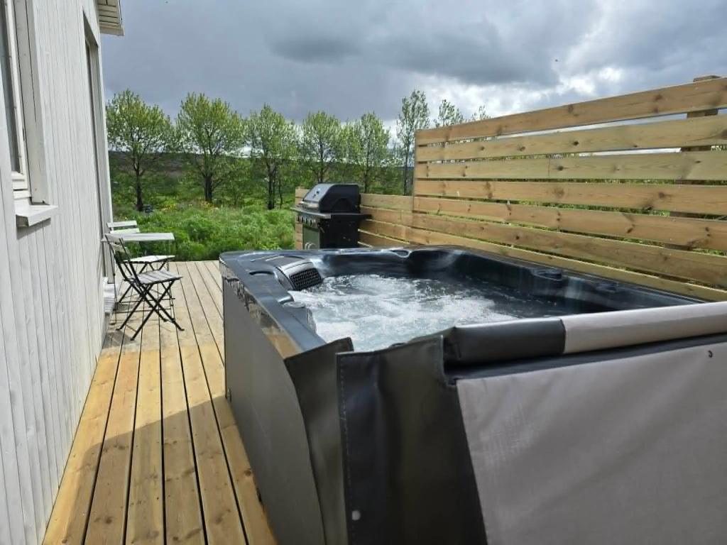 a hot tub on a deck with a grill at Romantic Cottage in Fludir