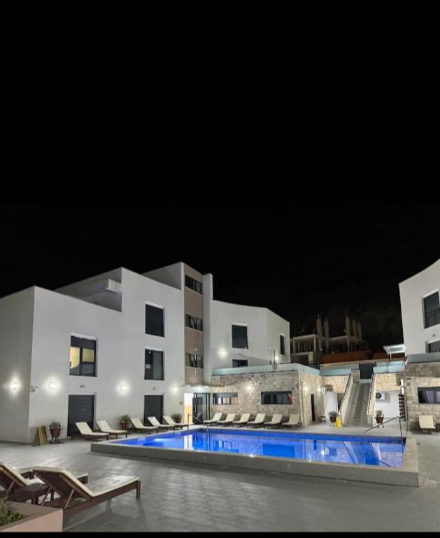 a large building with a swimming pool at night at DD Apartmani in Sutorina