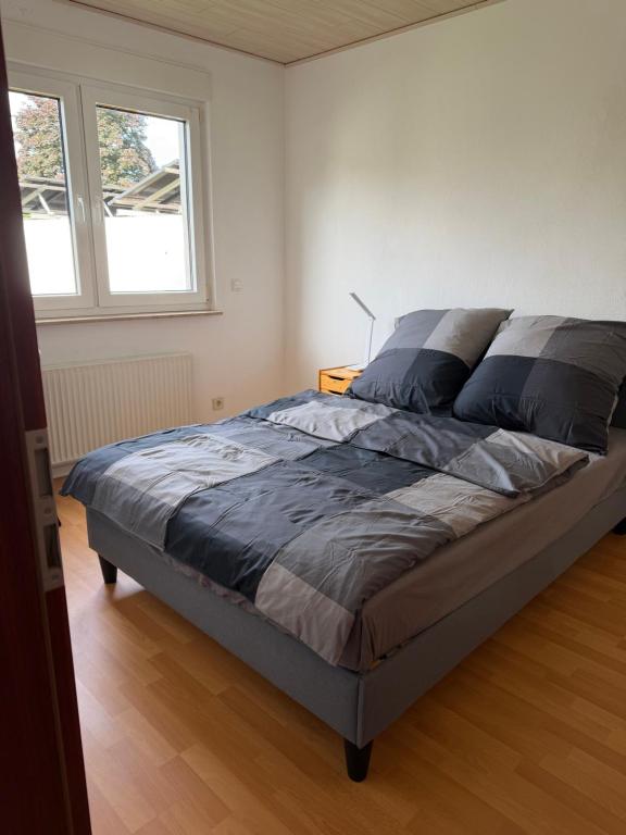 a bedroom with a bed in a room with two windows at Zimmer im Erdgeschoß mit Bad und Küche in Minden