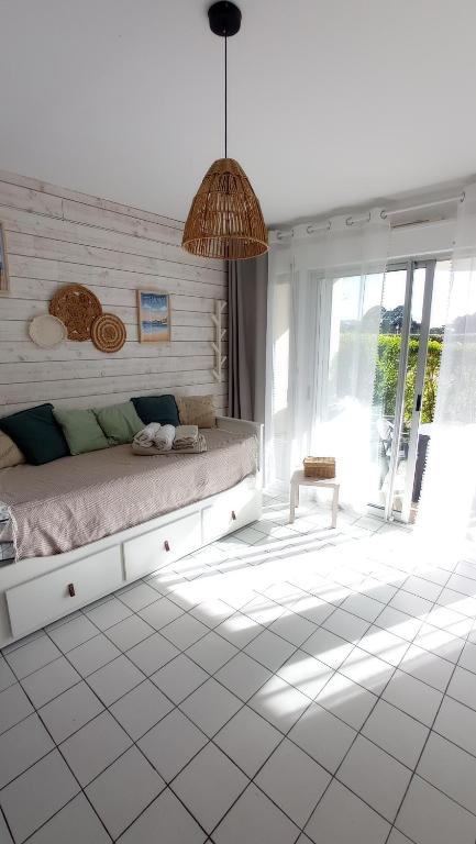 a bedroom with a bed and a large window at Studio l'Oasis - Piscine, plage de La Baule 10 min in Guérande