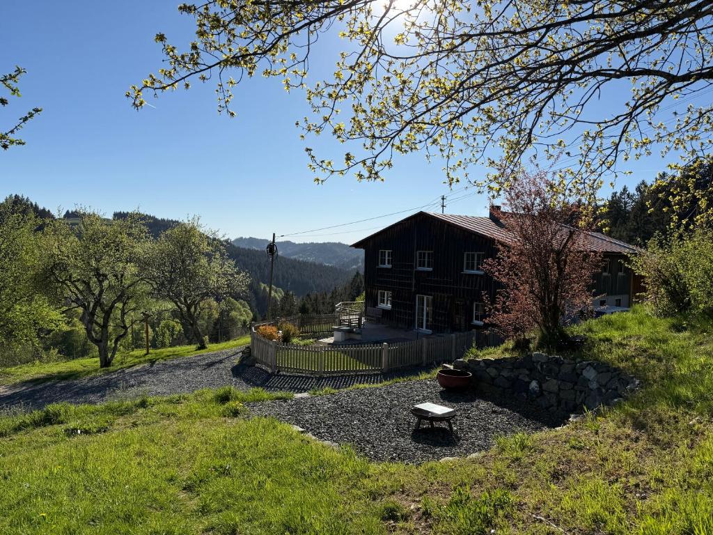 a house on a hill with a bench in front of it at Alpe Sonnenruh in Buchenberg
