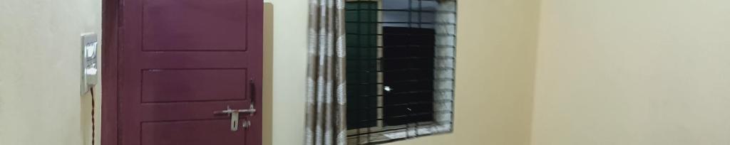 a purple door with a mirror next to it at Eden Homes in Honāvar