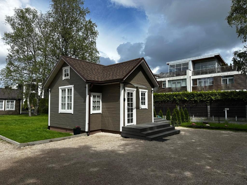a small house in front of a building at Melluži tiny house 35m2 in Jūrmala