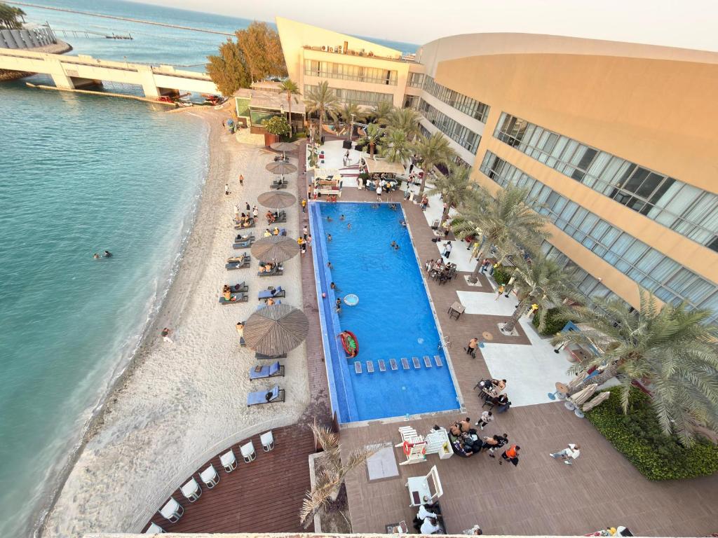 an overhead view of a swimming pool next to a beach at Dragon Beach Hotel in Manama