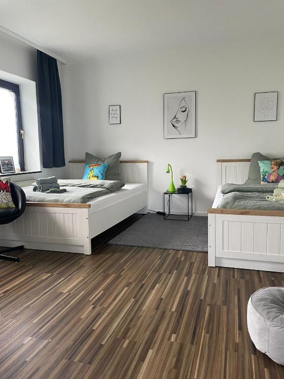 ein Schlafzimmer mit zwei Betten und Holzboden in der Unterkunft Design Quartier 6 Family&Business in Neunkirchen