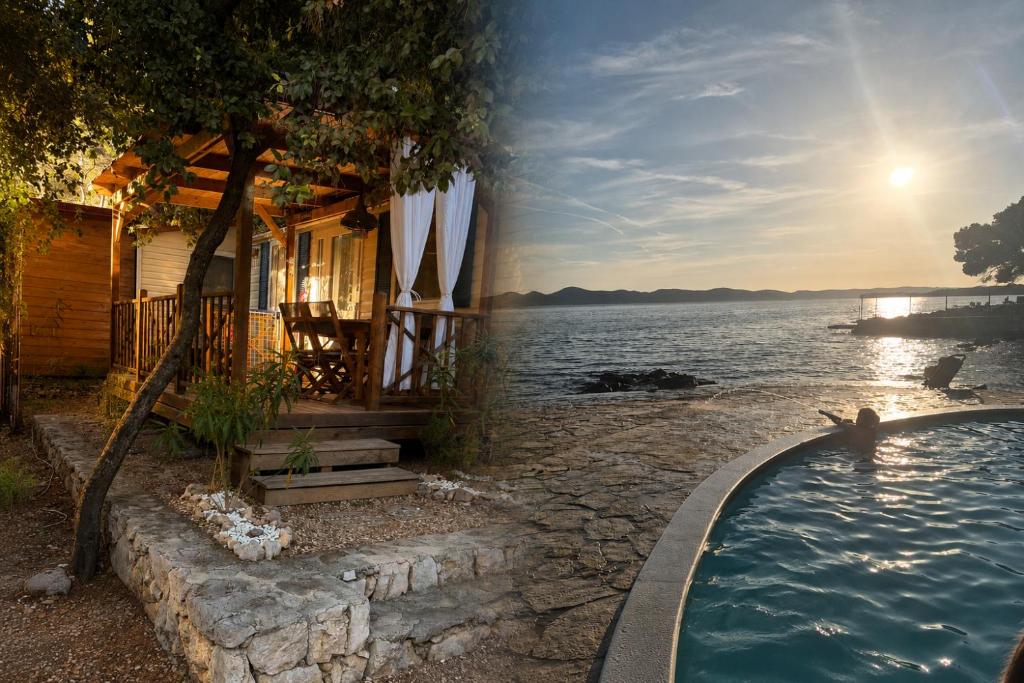 a house with a swimming pool next to a body of water at Glamour Pakoštane Mobile Home in Pakoštane