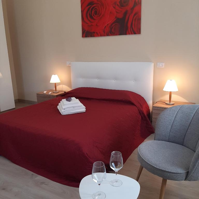 a bedroom with a bed with two chairs and wine glasses at Tuscany Hills - Comfort 10 minutes from Montepulciano and Pienza in Torrita di Siena