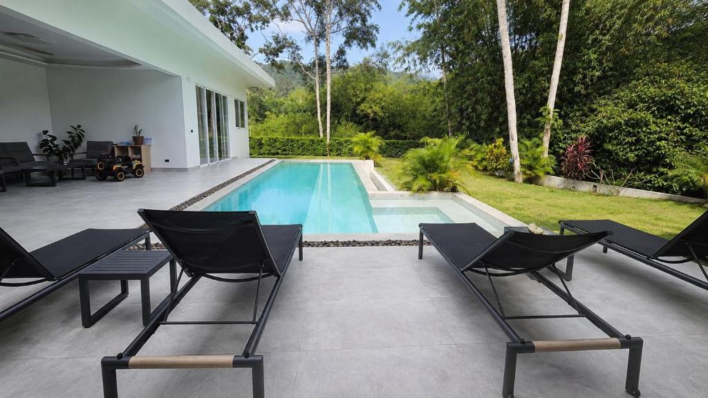 a swimming pool with two chairs and a swimming pool at villa Samuel in Koh Samui