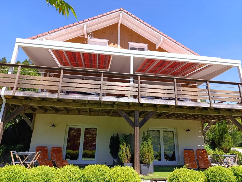 a house with a large deck and chairs at L'Eden de Floridylle in Xonrupt-Longemer