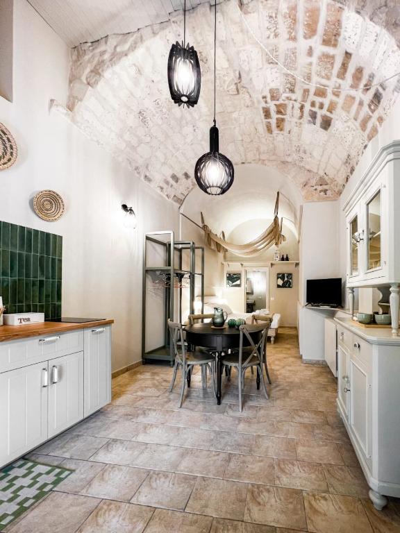 a kitchen with a table and a dining room at Lues Incanto in Ragusa