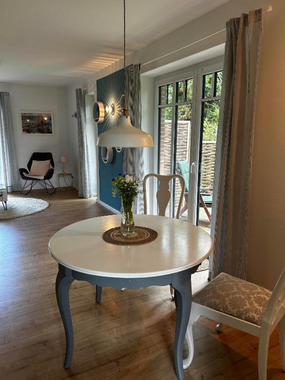 a dining room table with a vase of flowers on it at Auszeit in Hasselberg