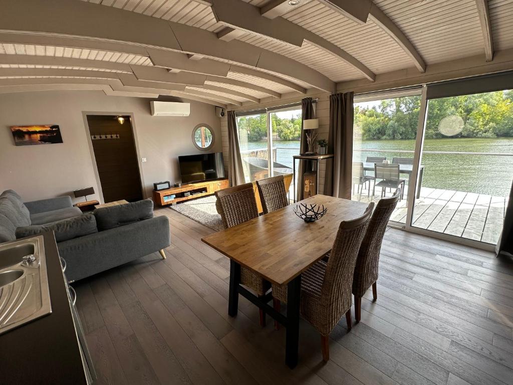 a living room with a table and a couch at Maison bord de Seine à 20 min de Paris in Villennes-sur-Seine
