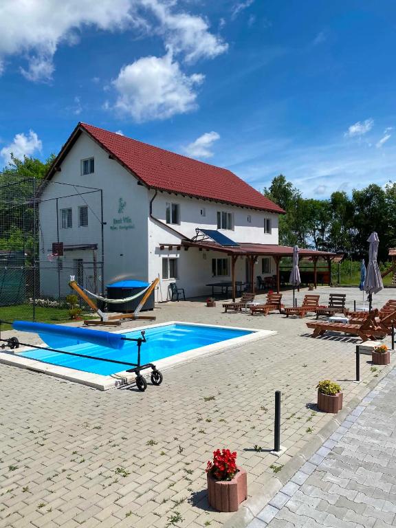 a swimming pool in front of a building at Best Vila Valea Avrigului in Avrig