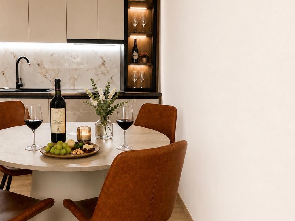 a table with two glasses of wine and a plate of fruit at Teslić CITY Apartment in Teslić