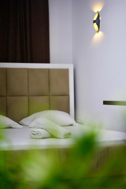 a bed with a light on top of it at Hotel Heimli in Prishtinë