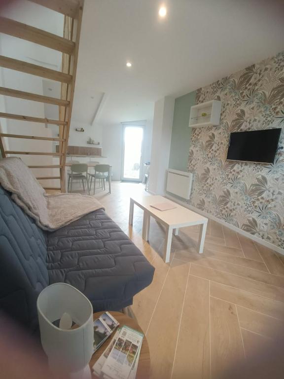 a living room with a couch and a table at La parenthèse Audomaroise in Heuringhem