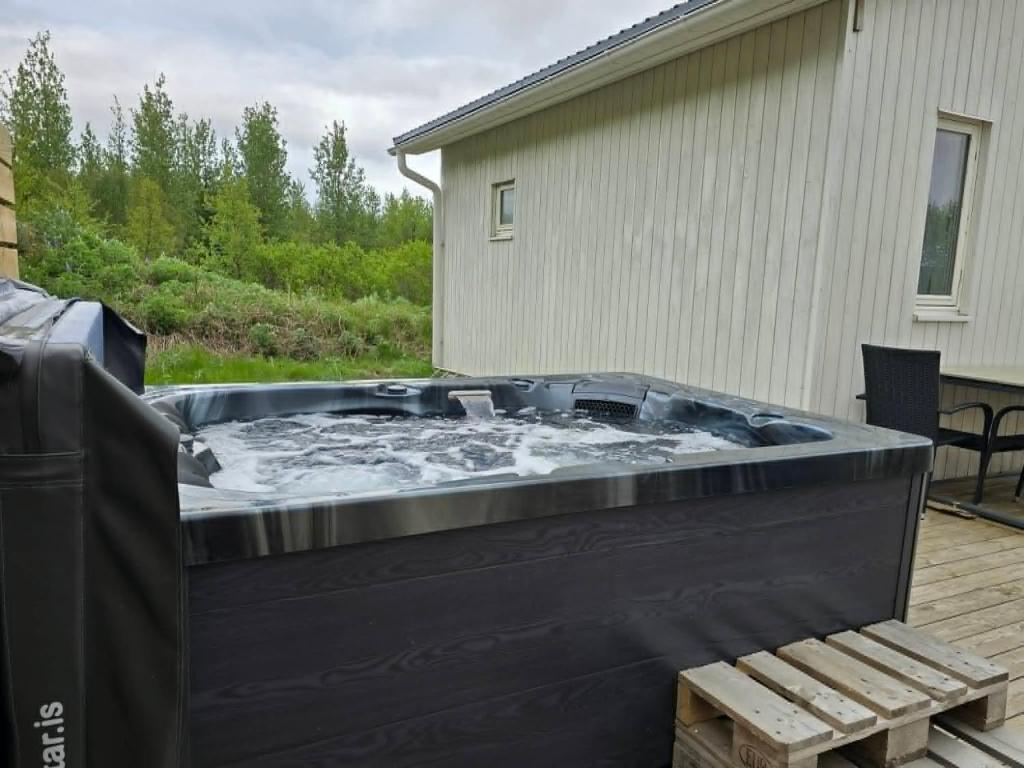 a jacuzzi tub on a deck in a yard at Romantic Getaway in Fludir