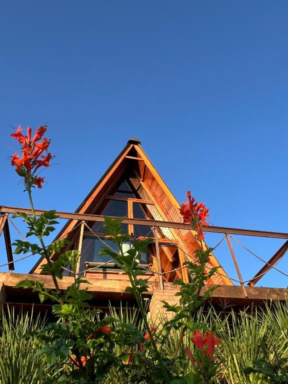 a house with a thatched roof with flowers at Chalé Nascer do Sol 2 in Massaranduba